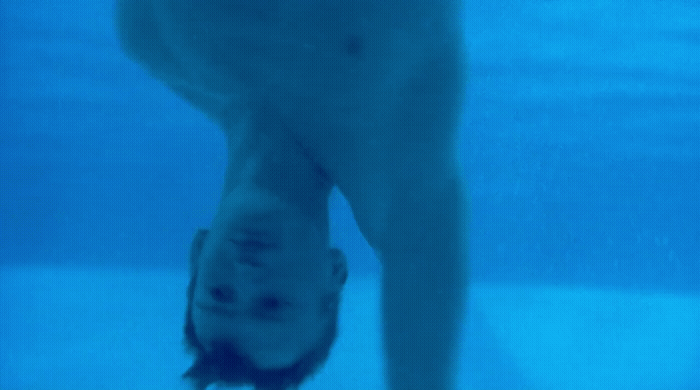 a man standing under water in a swimming pool