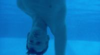 a man standing under water in a swimming pool