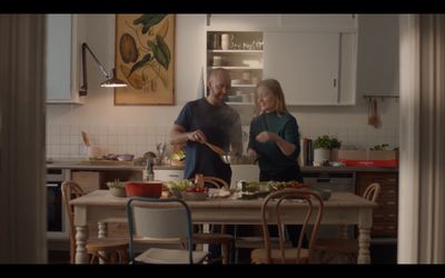 a man and a woman preparing food in a kitchen