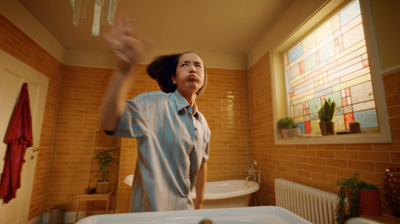 a woman standing in a bathroom next to a sink