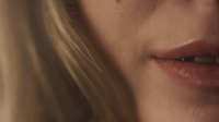 a close up of a woman's face with a tooth brush in her mouth