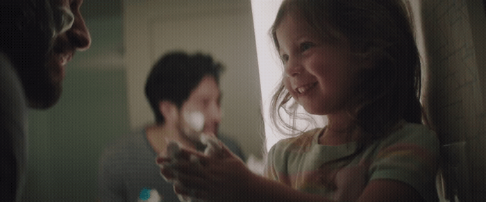 a little girl holding a nintendo wii game controller