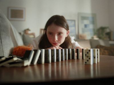 a woman leaning on a table with dominos in front of her