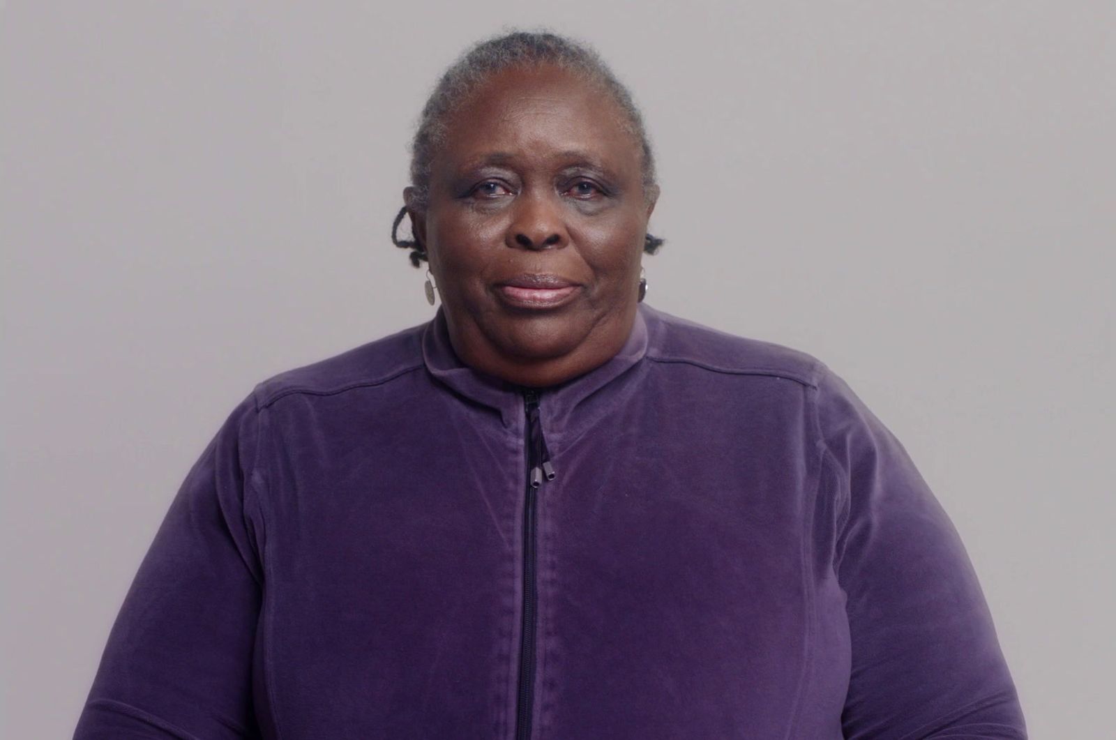 a woman in a purple jacket posing for a picture