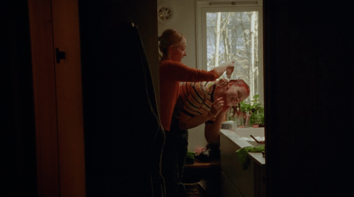 a woman standing next to a child in a kitchen