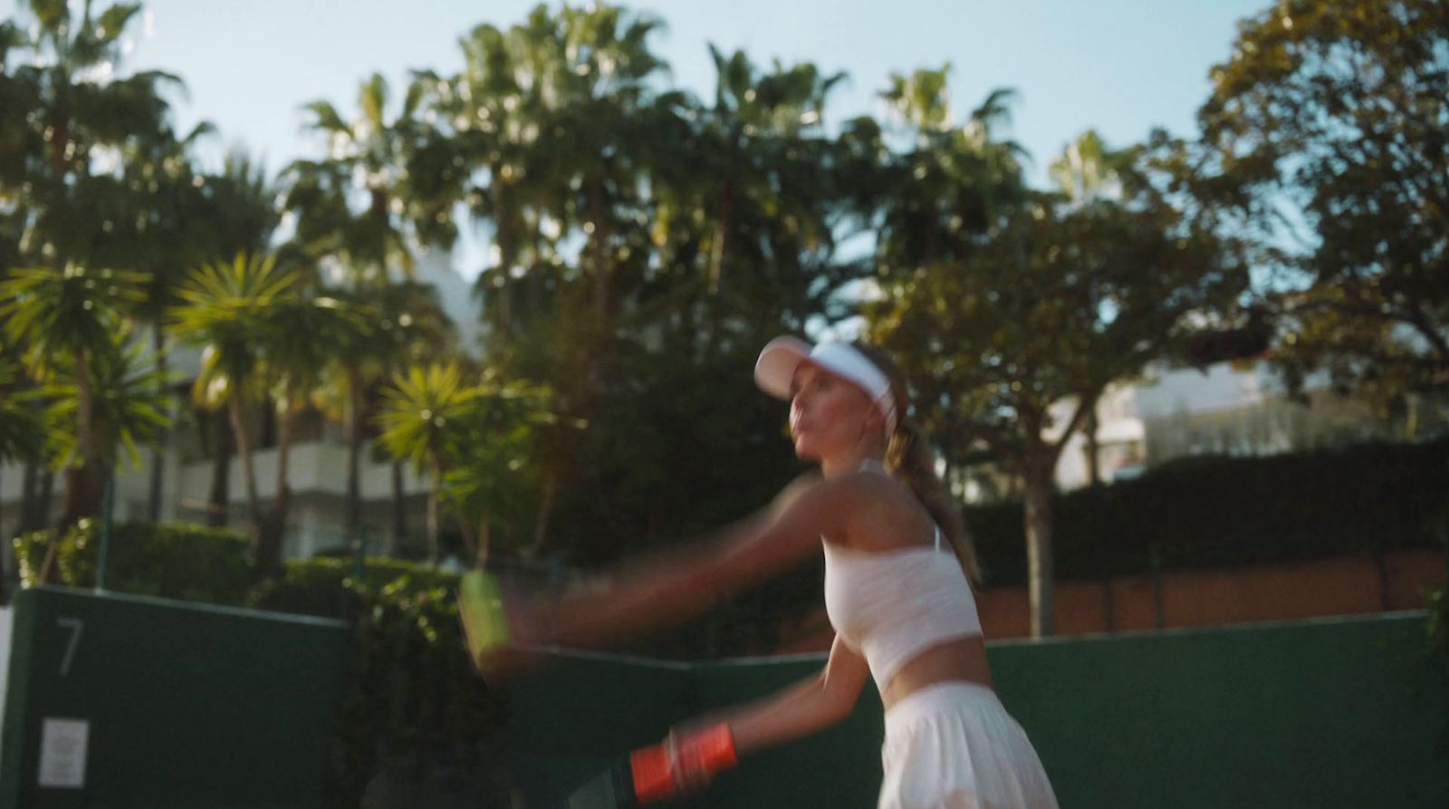 a woman swinging a tennis racquet on a tennis court