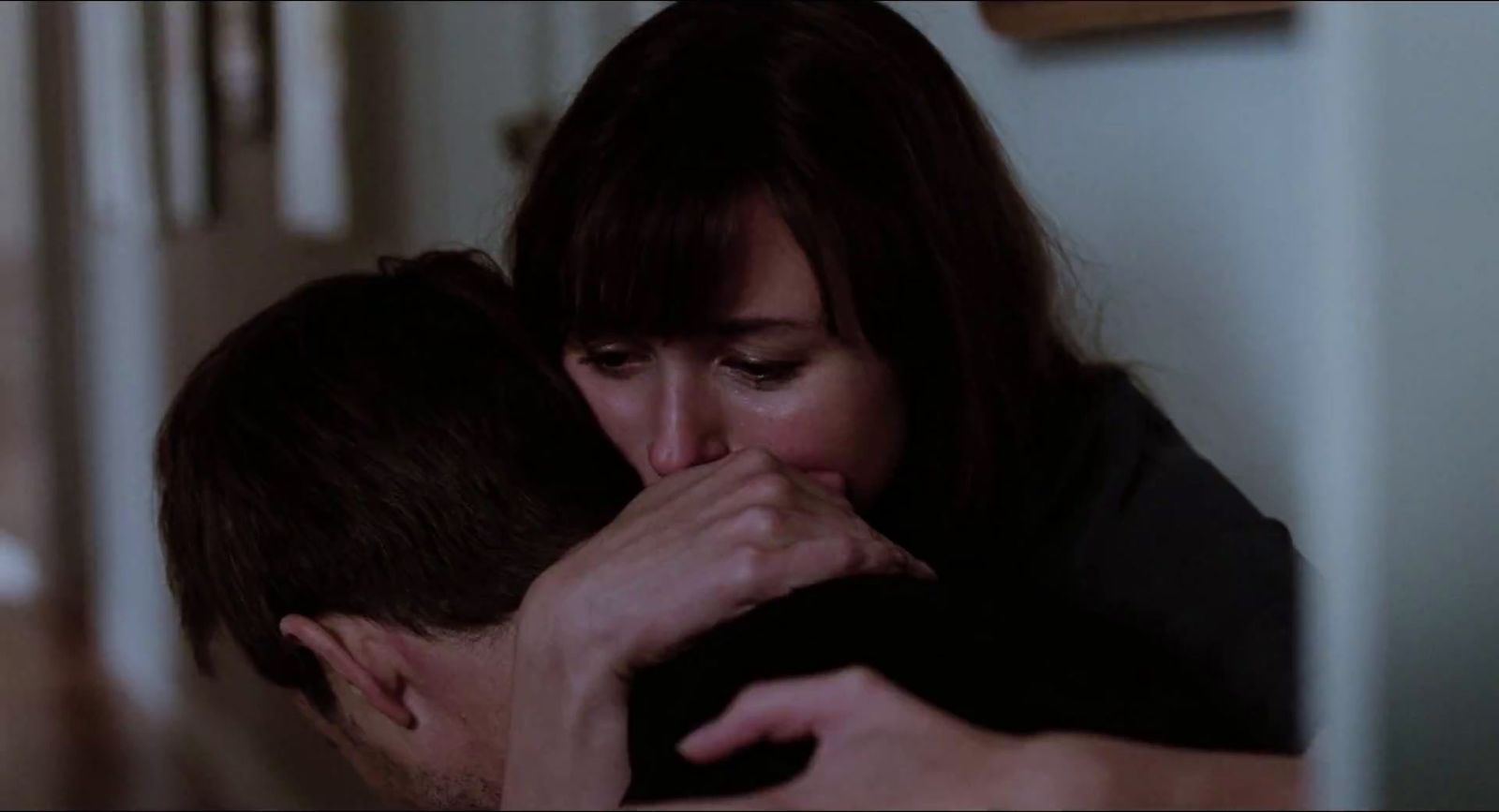 a man and a woman kissing in a room