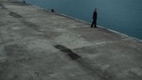 a person standing on a pier next to a body of water