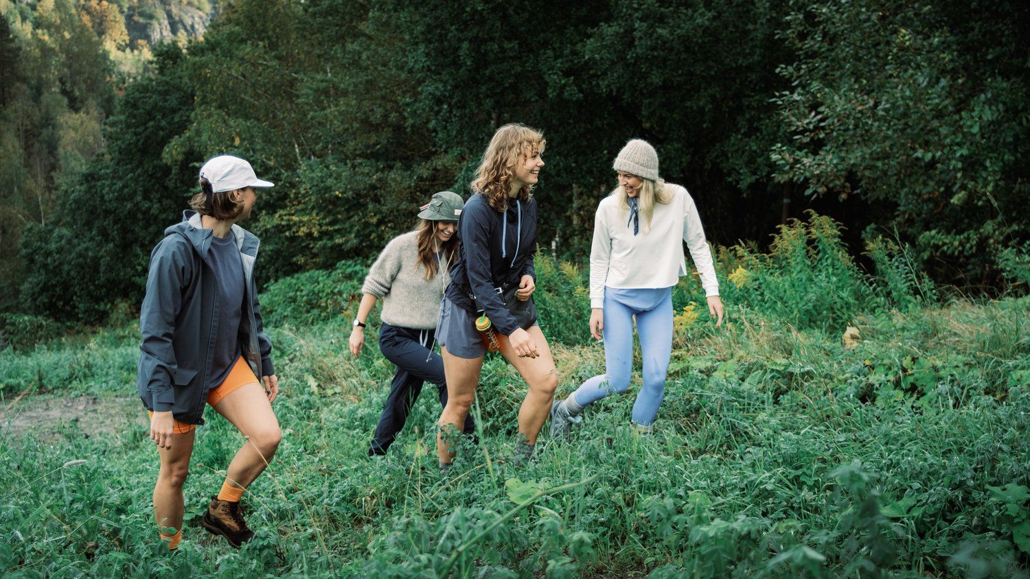 a group of people walking through a lush green field