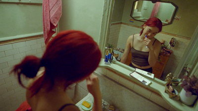 a woman brushing her hair in front of a mirror