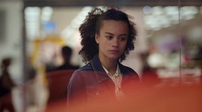 a woman with curly hair looking at her cell phone