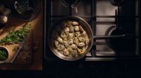 a pan filled with food sitting on top of a stove