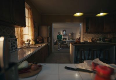 a man standing in a kitchen next to a counter