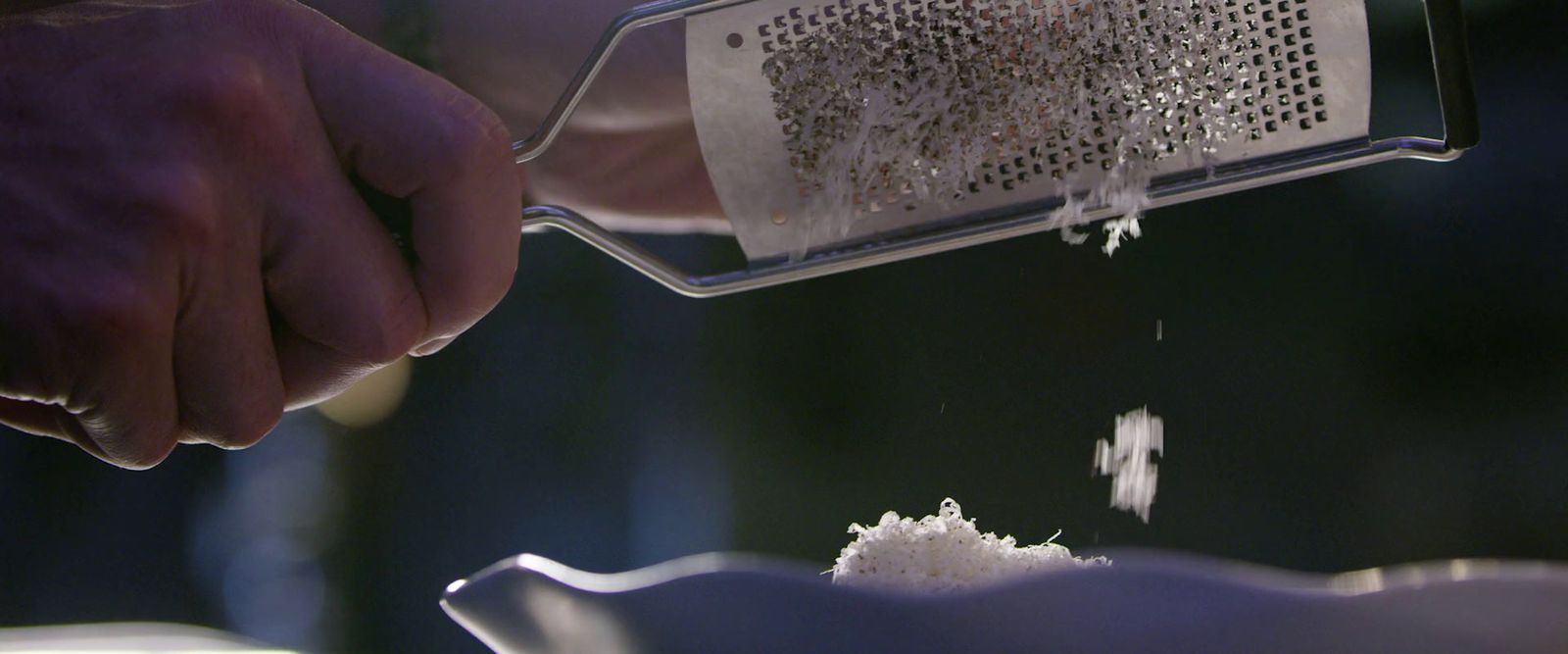 a person grating sugar into a grater