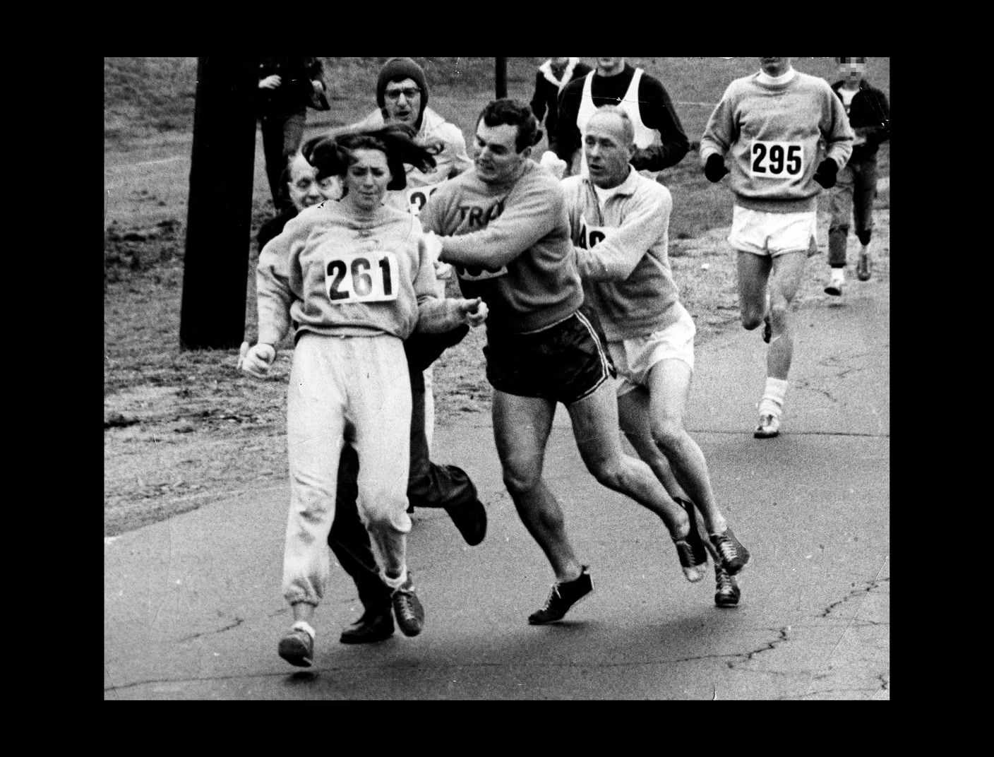 a black and white photo of a group of people running