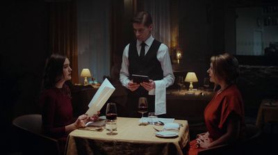 a man standing in front of a table holding a menu