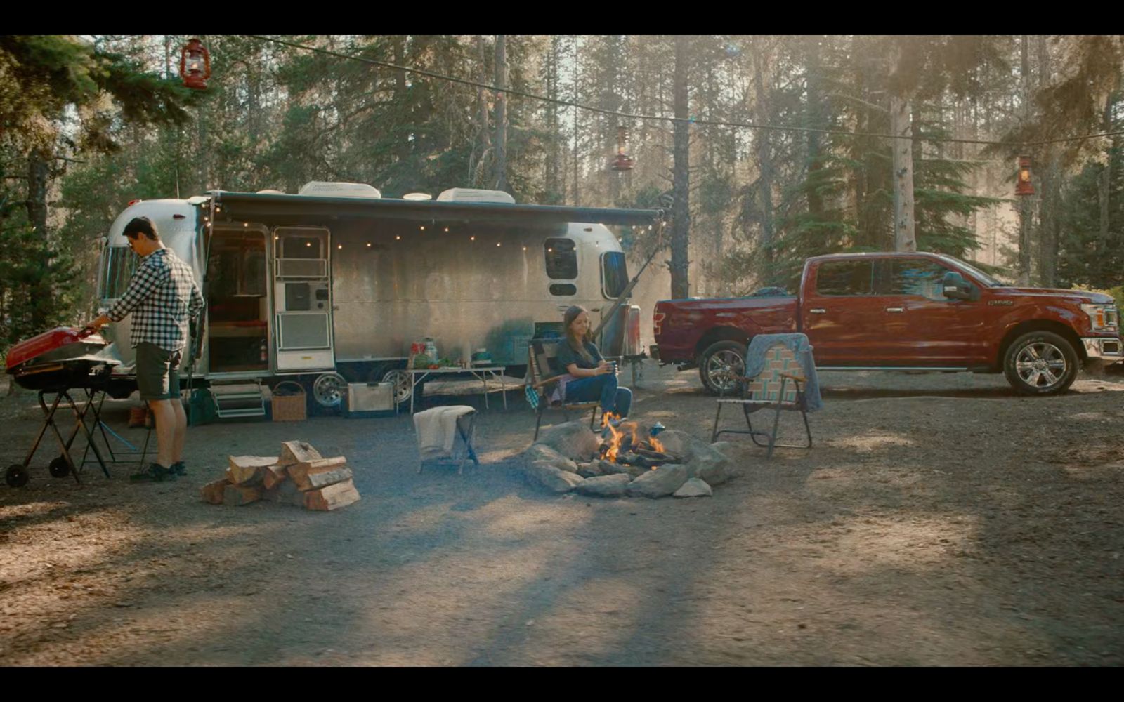 a couple of people sitting around a camper