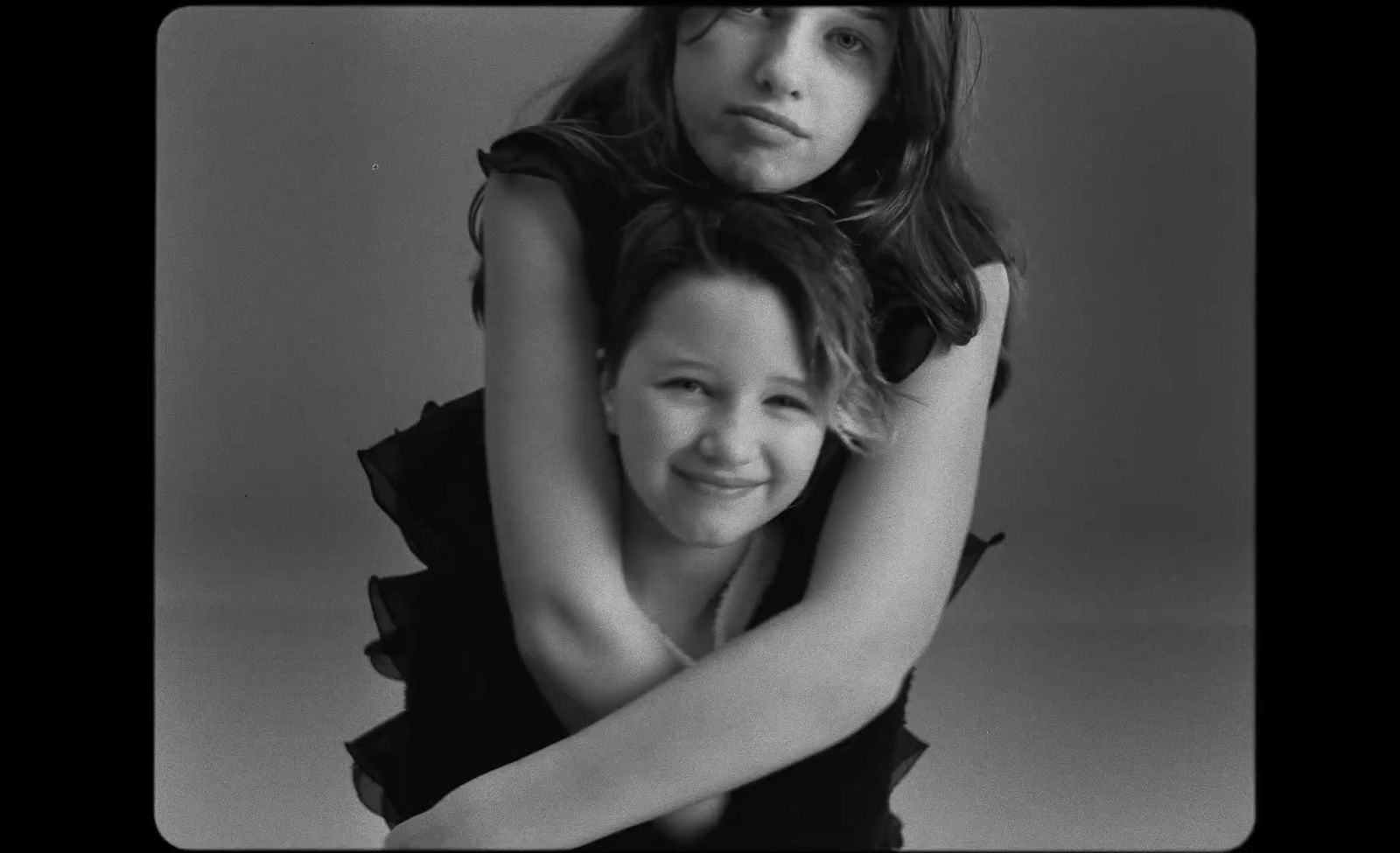 two women hugging each other in a black and white photo