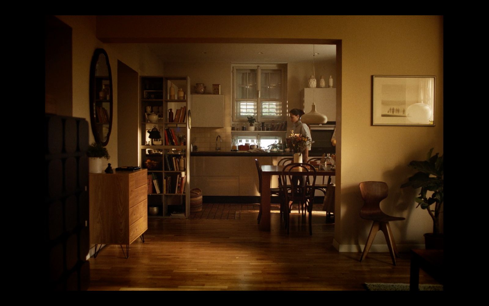 a man standing in a kitchen next to a table