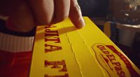 a person holding a piece of yellow paper with red writing on it