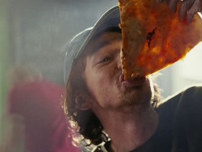 a man holding a slice of pizza up to his face