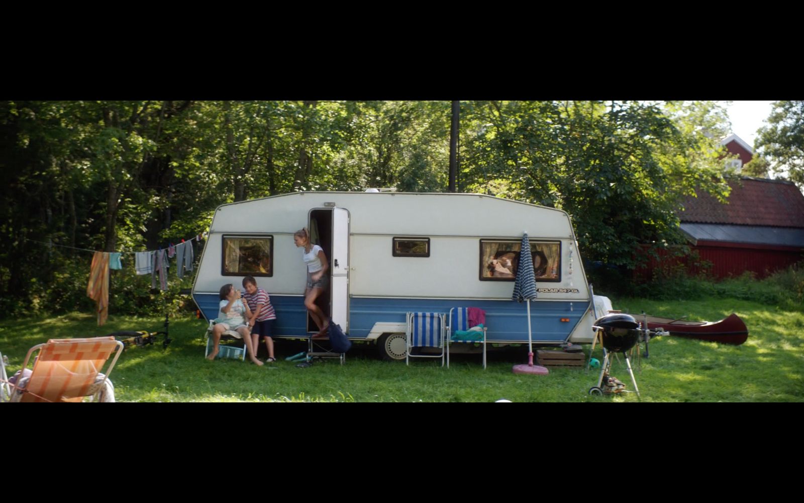 a group of people sitting around a camper