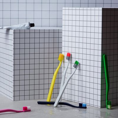 a couple of toothbrushes sitting on top of a bathroom floor