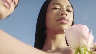 a close up of a person holding a flower