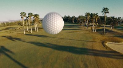 a golf ball flying over a golf course