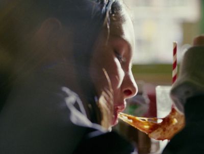 a young girl eating a piece of pizza