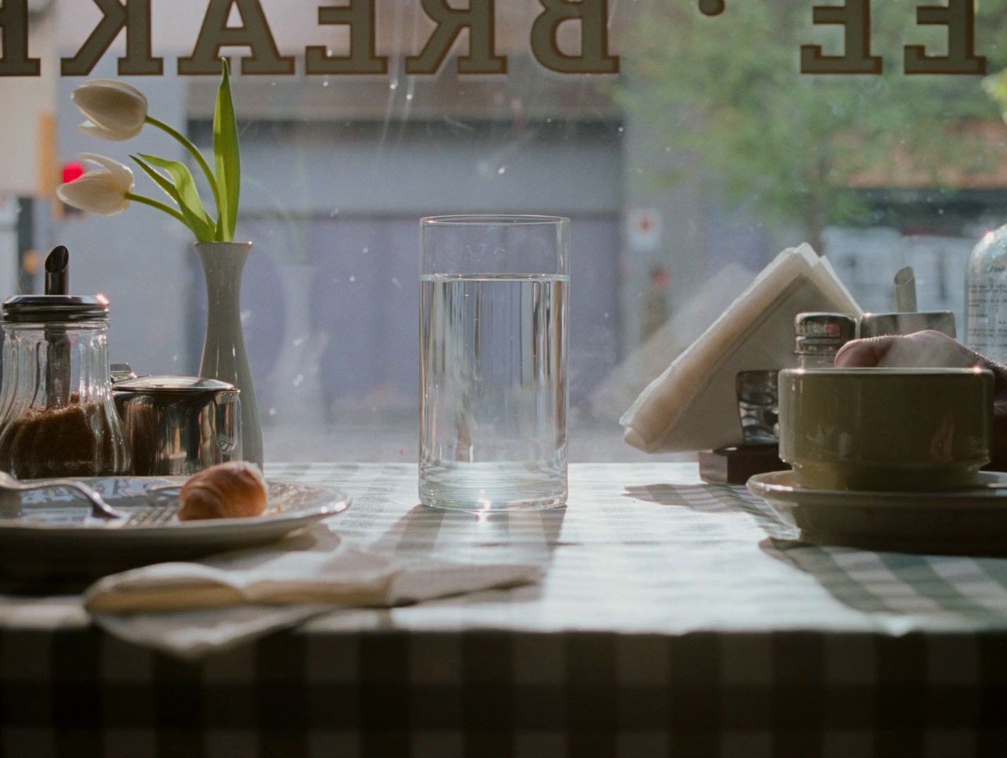 a table with a plate of food and a glass of water