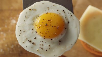 a fried egg sitting on top of a cutting board