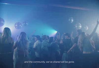 a group of people standing around each other in a room