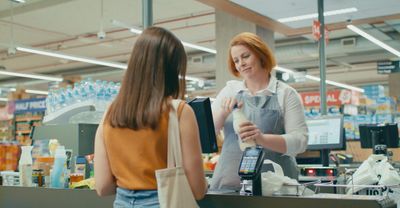 a woman in a grocery store talking to another woman