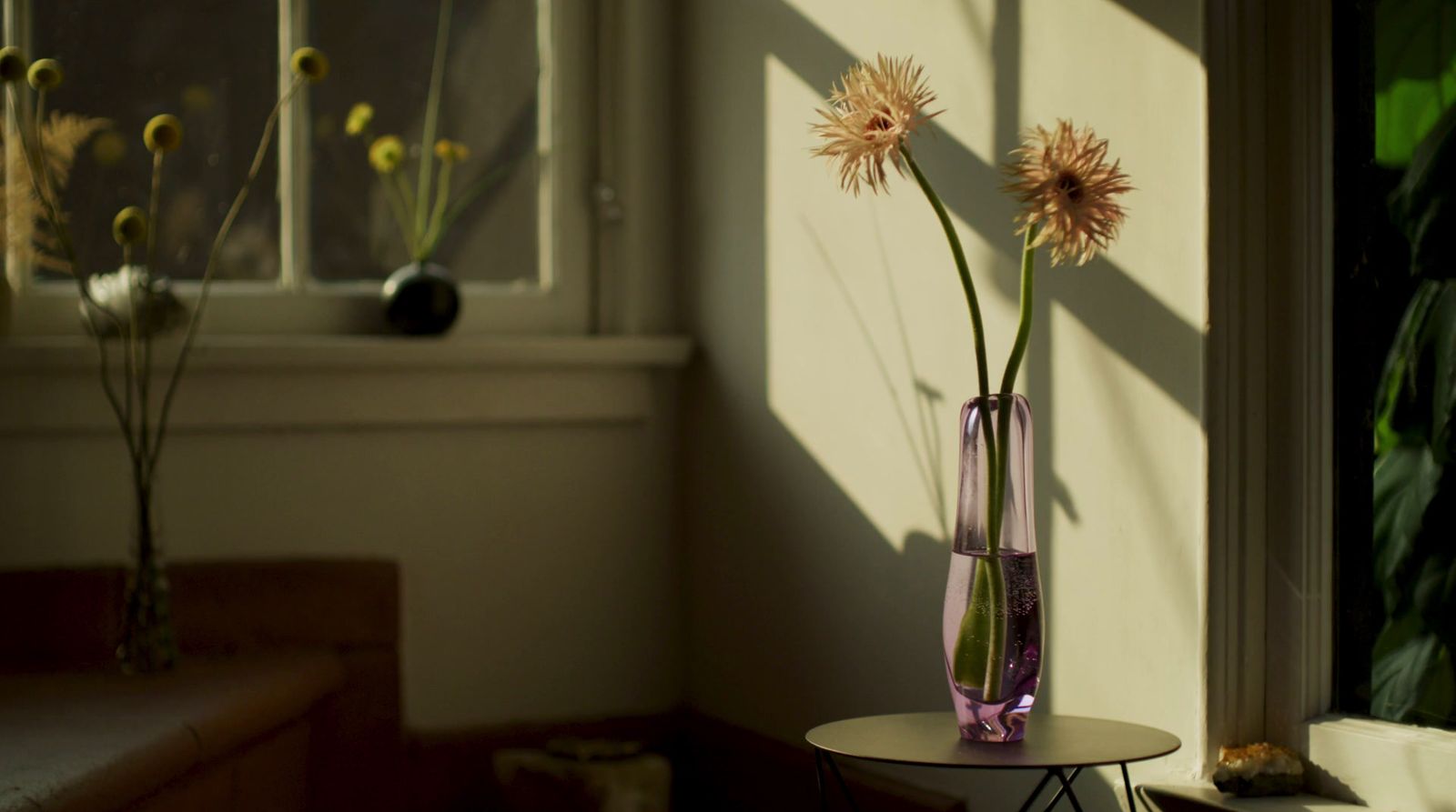 a vase of flowers sitting on a table next to a window