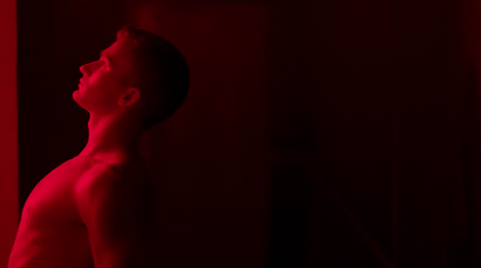 a man standing in front of a red light