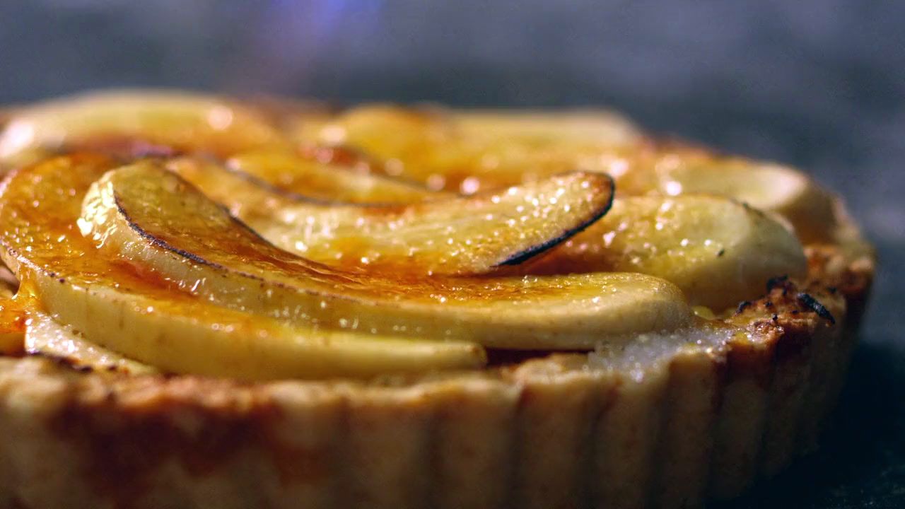 a close up of a tart with sliced bananas on top