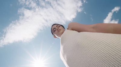 a woman standing in front of a bright blue sky