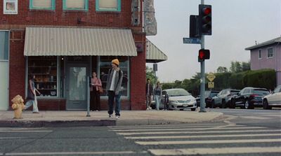 a man walking across a street next to a traffic light