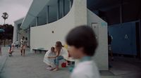 a group of people sitting on a bench in front of a building
