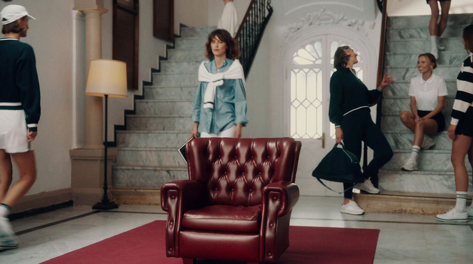 a group of people standing around a red chair