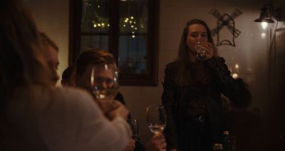 a group of people sitting around a table drinking wine