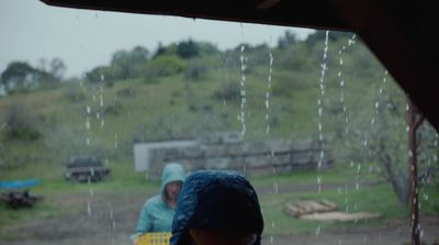 a couple of people that are standing in the rain