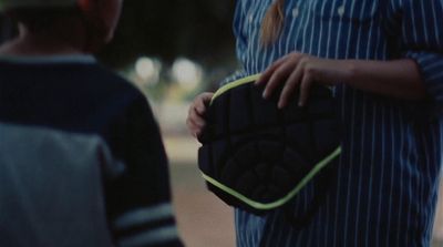 a woman holding a black and yellow case next to a man