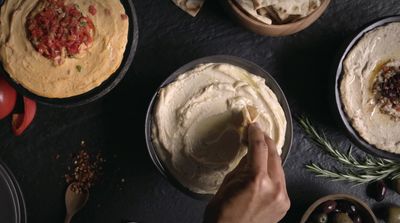 a person is putting toppings on a cake