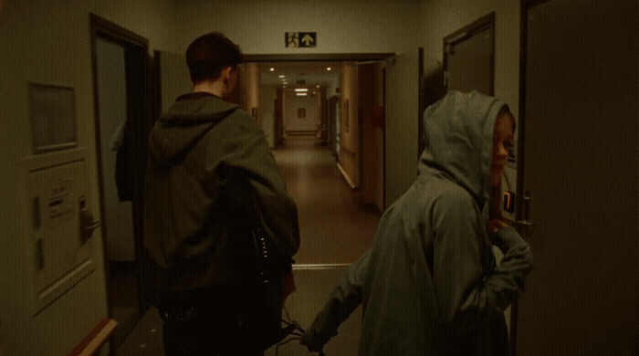 a couple of people walking down a hallway