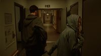 a couple of people walking down a hallway