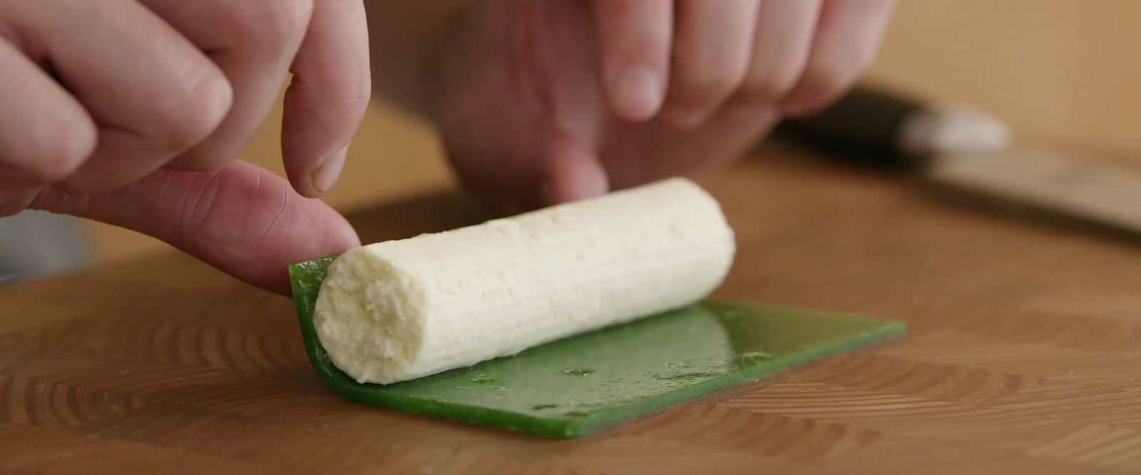 a person cutting a piece of food with a knife