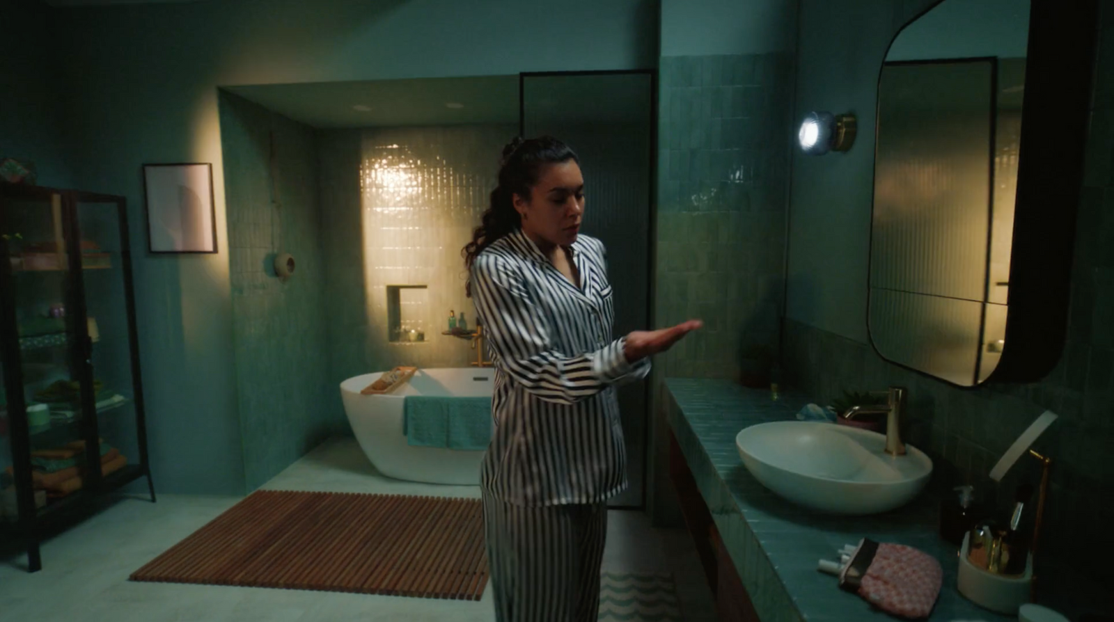 a woman standing in a bathroom next to a sink