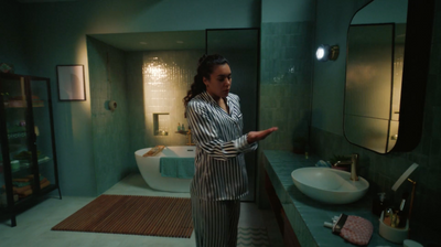 a woman standing in a bathroom next to a sink